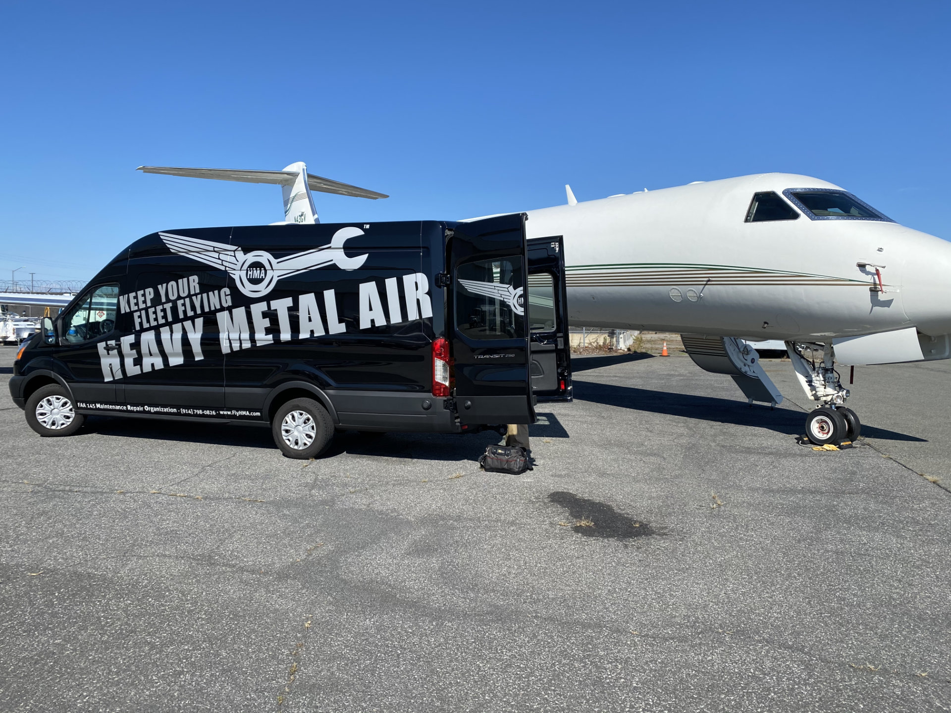 Heavy Metal Air mobile service van parked beside a business jet on the ramp