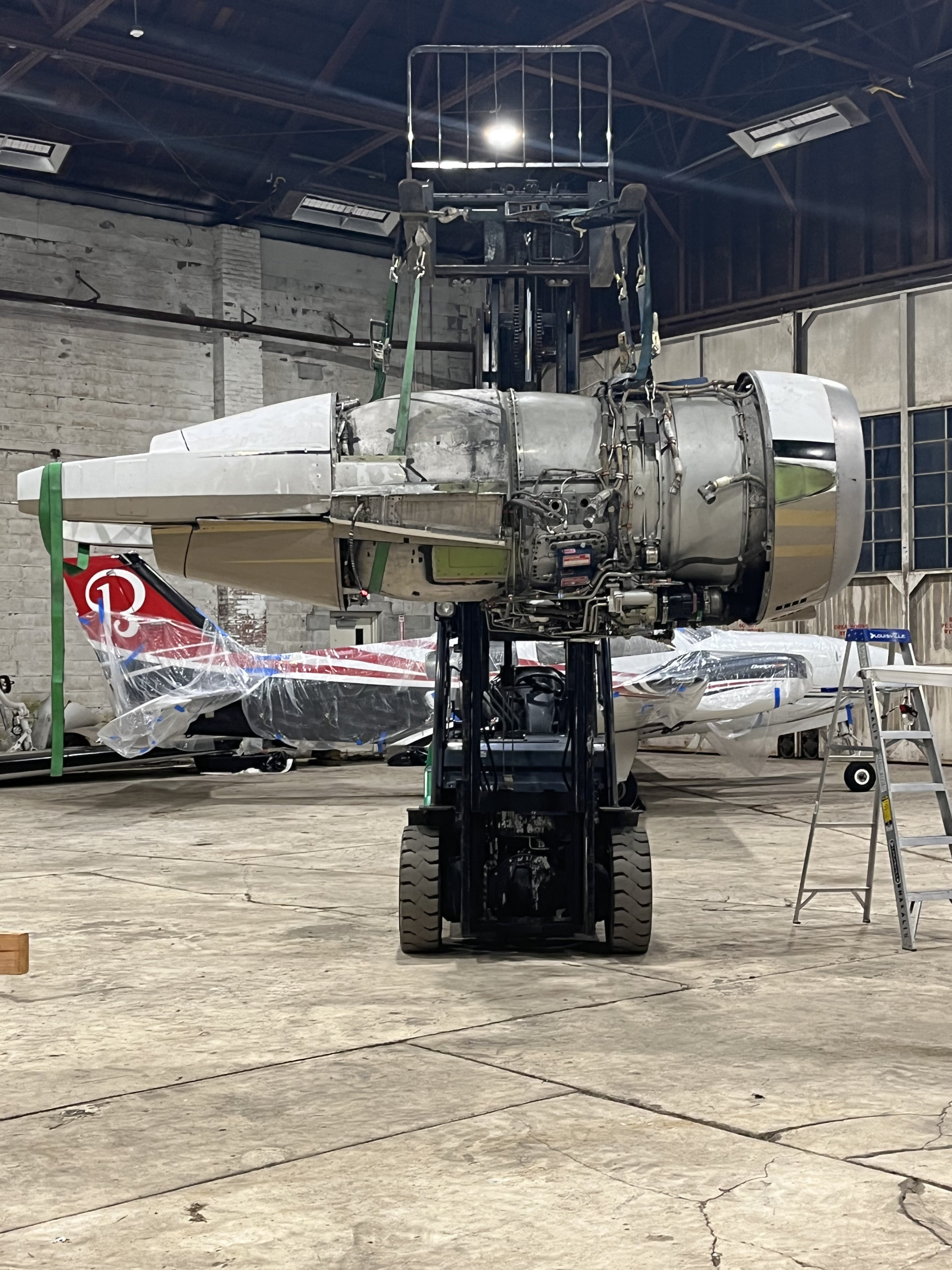 Aircraft engine removed and supported on a stand inside the Heavy Metal Air hangar