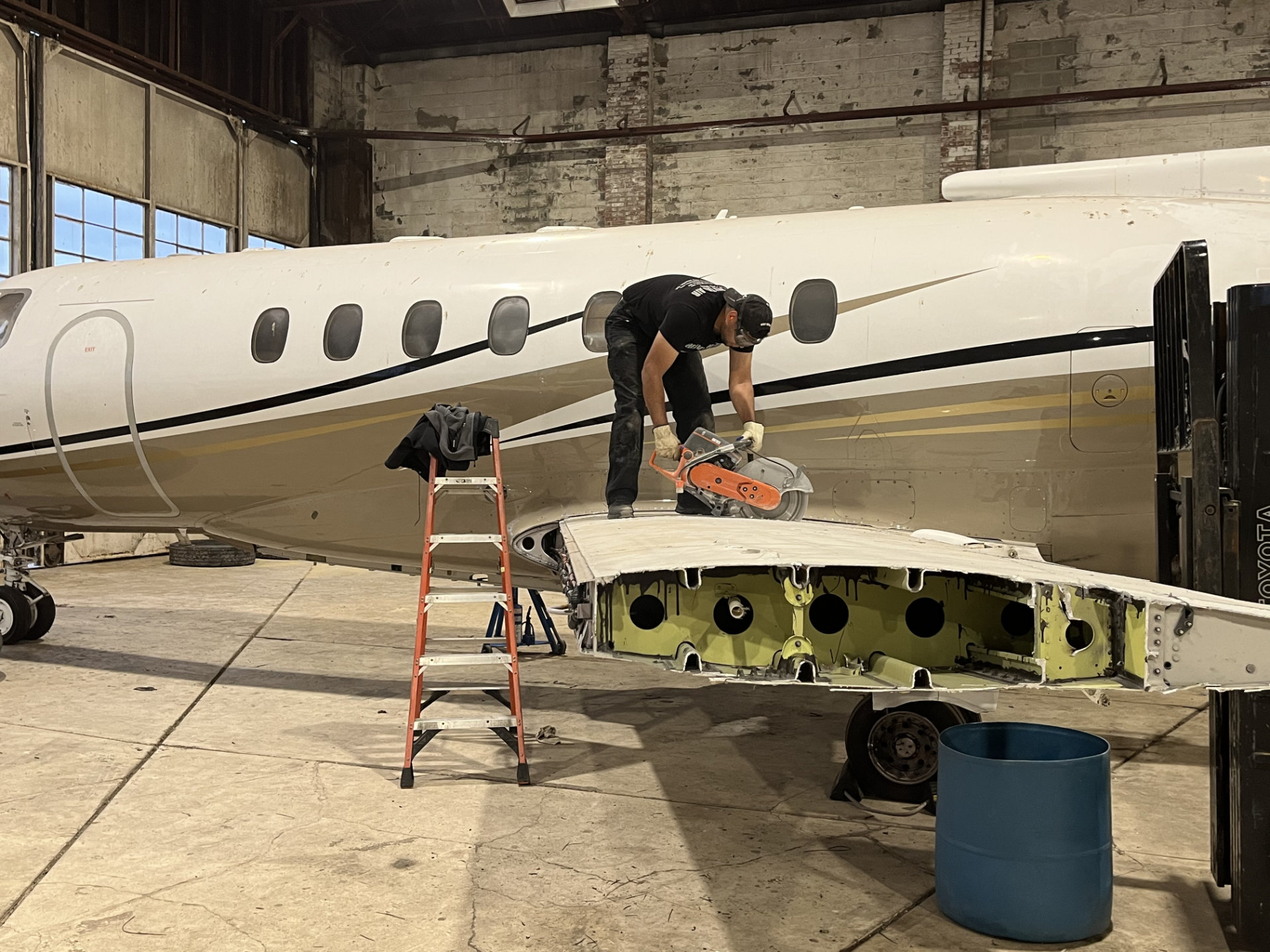 Business jet in the Heavy Metal Air hangar with wing access panels opened for inspection